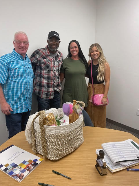 A client family holding a closing gift basket with David Benson after completing their purchase